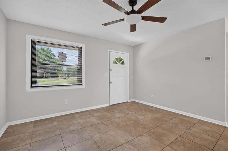 Empty room with window, ceiling fan and tile flooring at 7453 Jade Dr N, Jacksonville, FL 32210