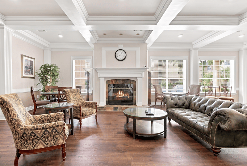 Clubhouse living area with fireplace and coffered ceiling in Reserve at Point Meadows