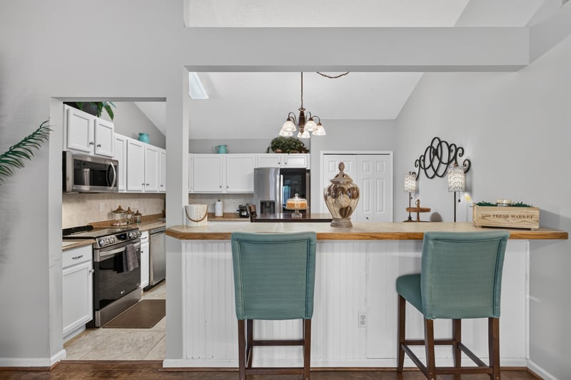 Kitchen breakfast bar with teal stools at 3067 Wavering Ln, Middleburg, FL 32068