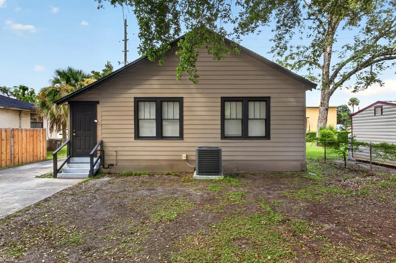 Side exterior with wood siding, black windows and AC unit at 316 W 41st St, Jacksonville, FL 32206