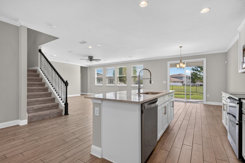 Open kitchen and living area with staircase at 2580 Cold Stream Ln, Green Cove Springs, FL 32043