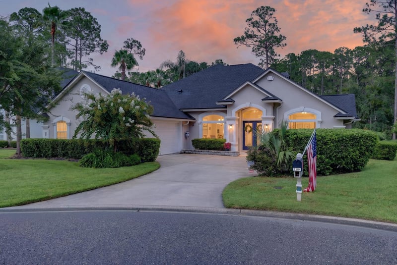 Front exterior at day-to-dusk with porch lights on at 2304 Spring Hill Ct, Orange Park, FL