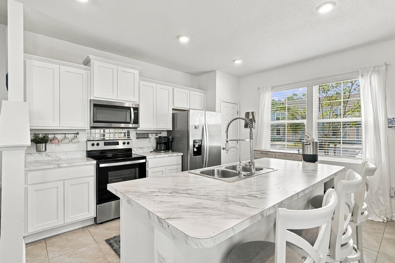 Kitchen with white cabinets, stainless range and window at 8359 Zenith Cir, Jacksonville, FL 32256