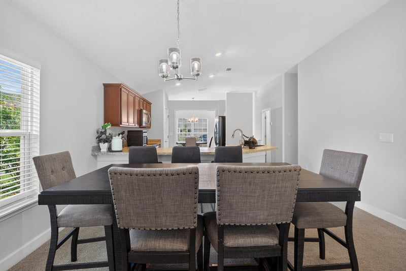 Dining area with upholstered chairs and chandelier at 9846 Olivia St, Jacksonville, FL