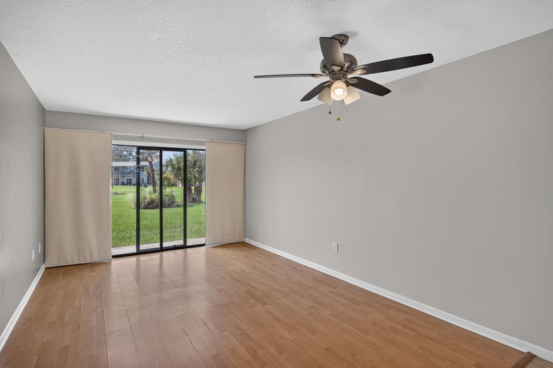 Living room with sliding glass doors to screened porch at 700 W Pope Rd unit h61, St. Augustine, FL 32080