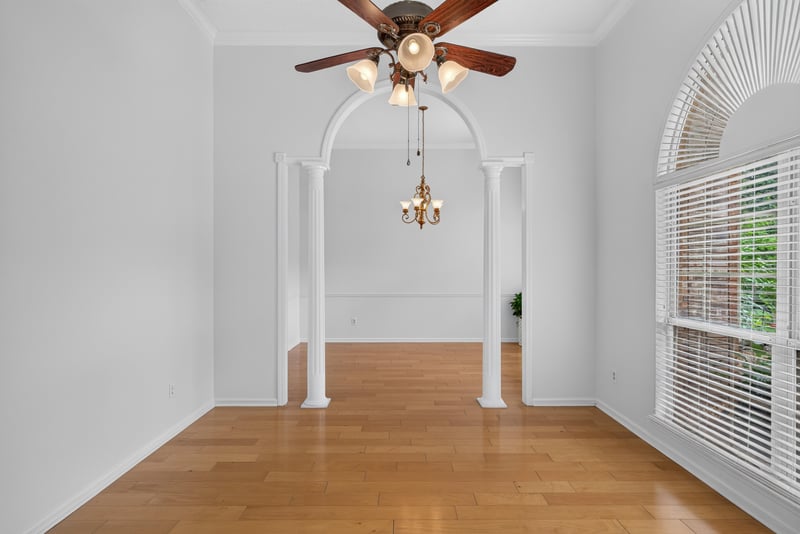 Living area with arched doorway and wood floors at 12810 Swamp Owl Ln