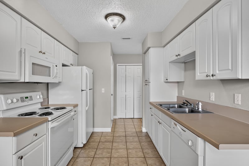 Kitchen with white cabinets and tile floor at 1800 Park Ave apt 358, Orange Park, FL