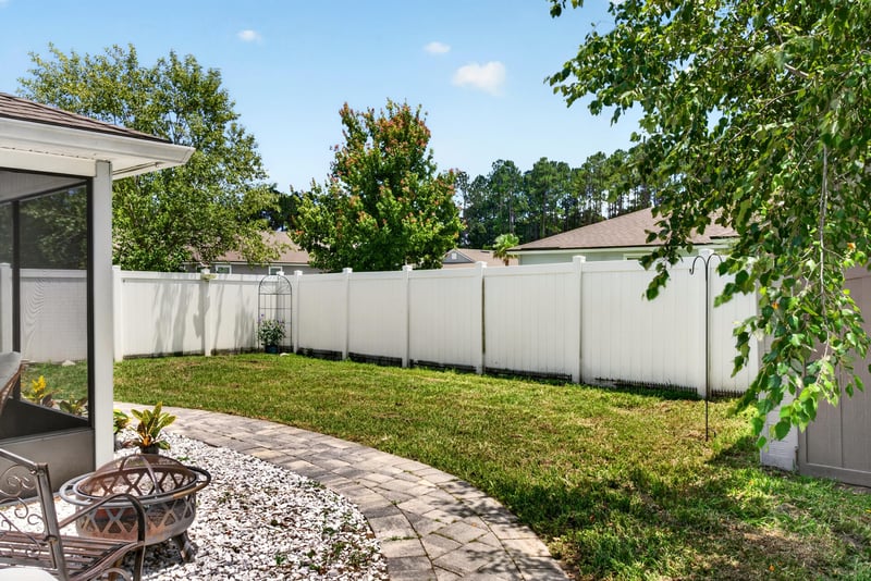 Backyard with white vinyl fencing and patio at 10066 Andean Fox Dr, Jacksonville, FL 32222