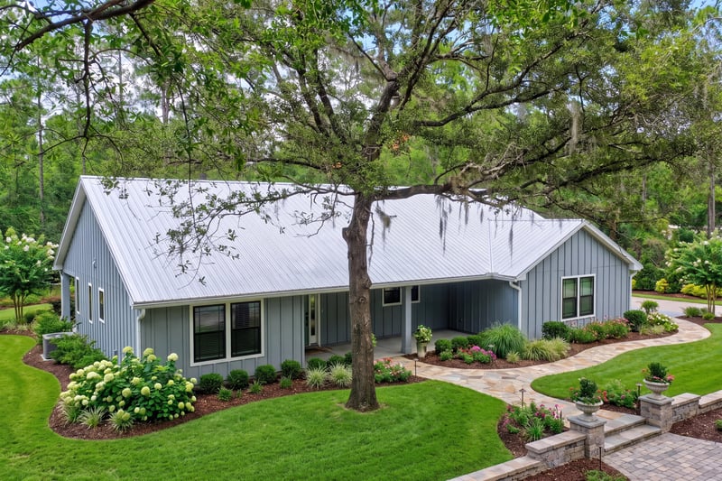 Front exterior with covered porch and mature oak tree at 4800 Acacia St, Middleburg, FL 32068