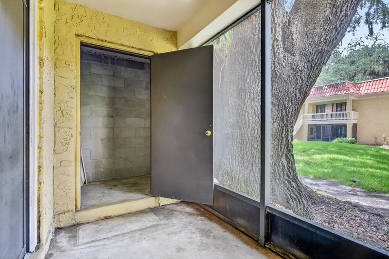 Screened porch with open door at 5811 Atlantic Blvd unit 47, Jacksonville, FL 32207