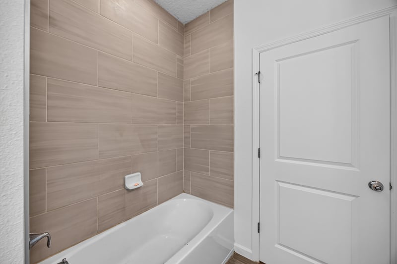 Bathroom tub-shower combo with tile surround at 9905 Ansley Lake Dr, Jacksonville, FL