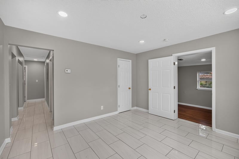 Hallway with tile floor and multiple doors at 7015 Miss Muffet Ln N, Jacksonville, FL 32210