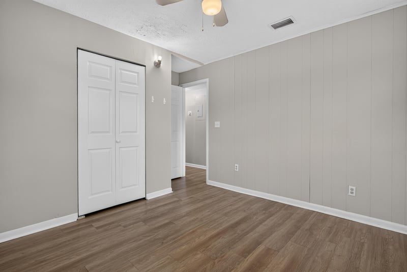 Bedroom with two windows and wood-look flooring at 255 Woodside Dr, Orange Park, FL 32073
