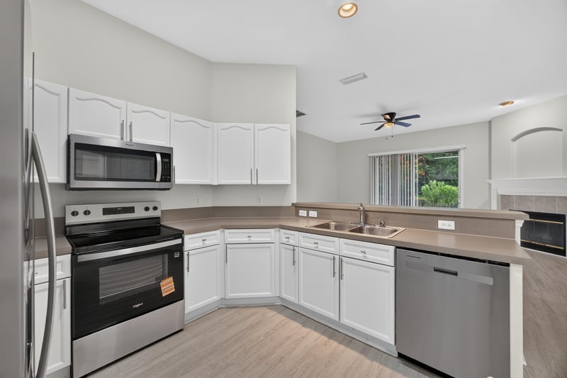 Kitchen with microwave, stove, and white cabinets at 706 Bonaparte Dr, Jacksonville, FL 32218