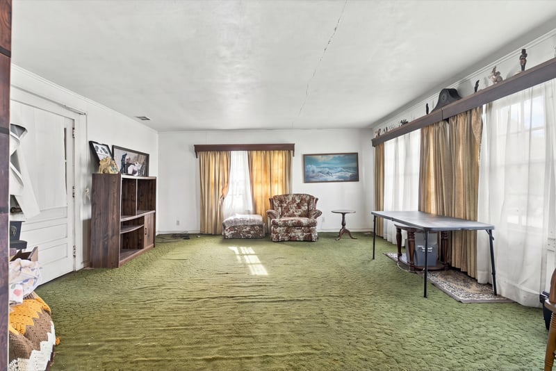 Living room with curtained windows and armchair at 1807 Idlewild Ave, Green Cove Springs, FL