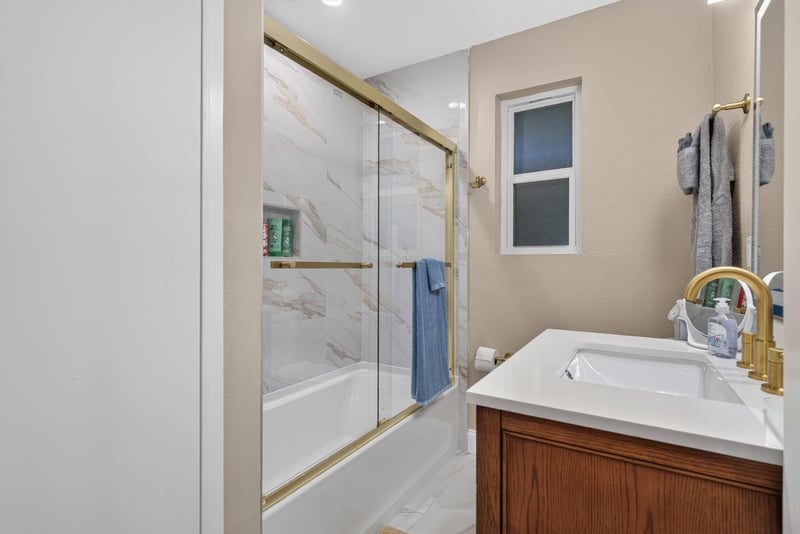 Bathroom with glass shower and marble tile at 1525 8th St N, Jacksonville Beach, FL