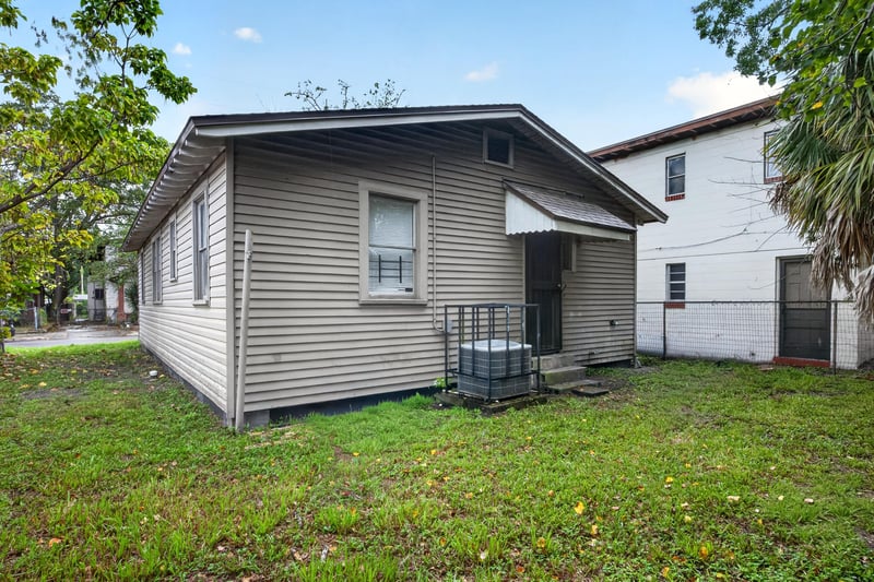 Rear exterior view with siding and air conditioning unit at 1473 State St W, Jacksonville, FL 32209