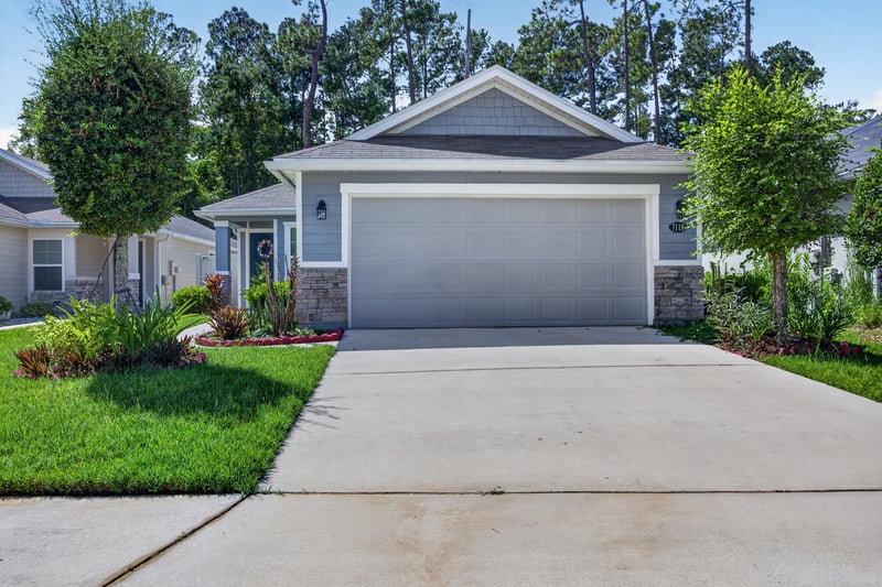 Front exterior showing garage and stone accent at 7118 Preston Pnes Trl, Jacksonville, FL
