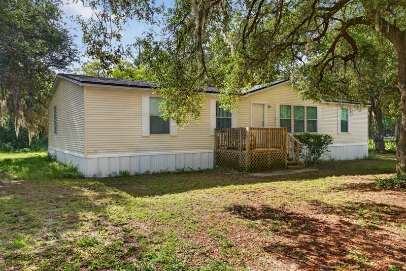 Front yard view with siding and oak canopy at 3215 Robin Ln, Middleburg, FL