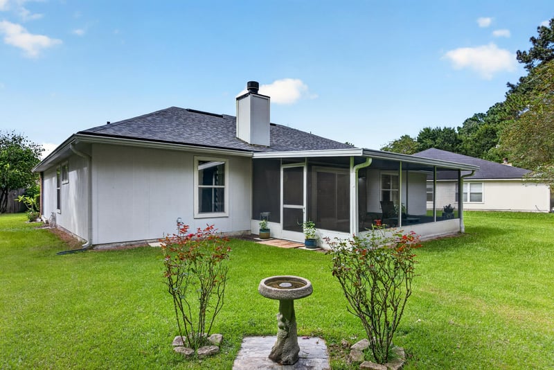 Backyard with screened porch and landscaped lawn at 13514 Las Brisas Way N, Jacksonville, FL