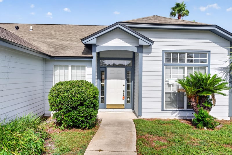 Front entry with stacked-stone accent and double window at 400 Ashcroft Landing Dr, Jacksonville, FL 32225