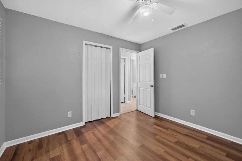 Hallway with wood-look flooring and closet doors at 4030 Leonard Cir W, Jacksonville, FL 32209