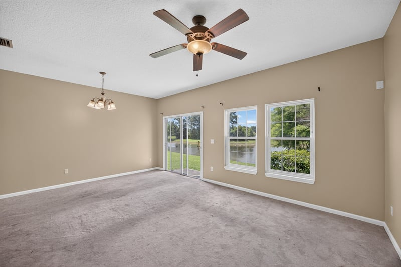 Living room with carpet and natural light from two windows at 1572 Biscayne Bay Dr, Jacksonville, FL 32218