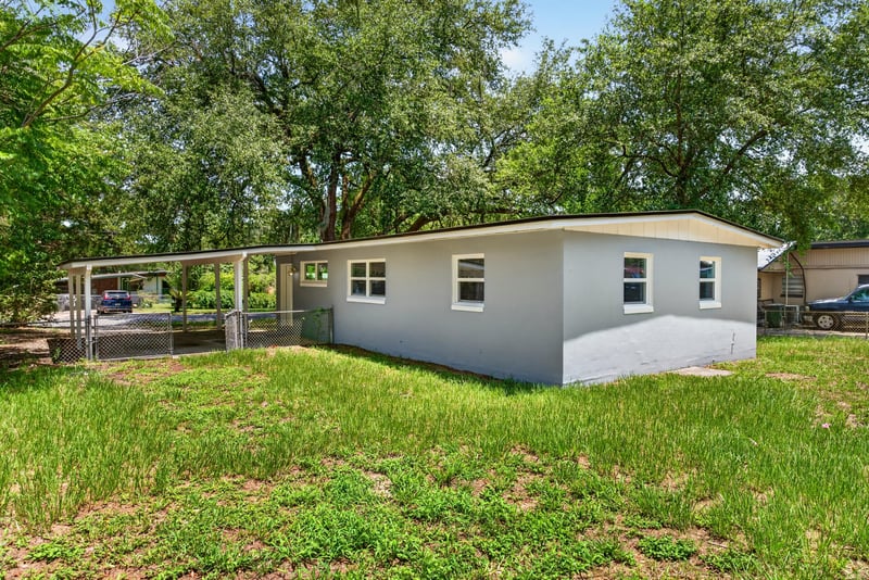 Backyard view with open lawn at 1928 Montmarte Dr, Jacksonville, FL 32210