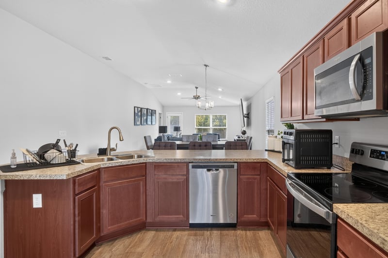 Kitchen with stainless dishwasher and granite counters at 9846 Olivia St, Jacksonville, FL