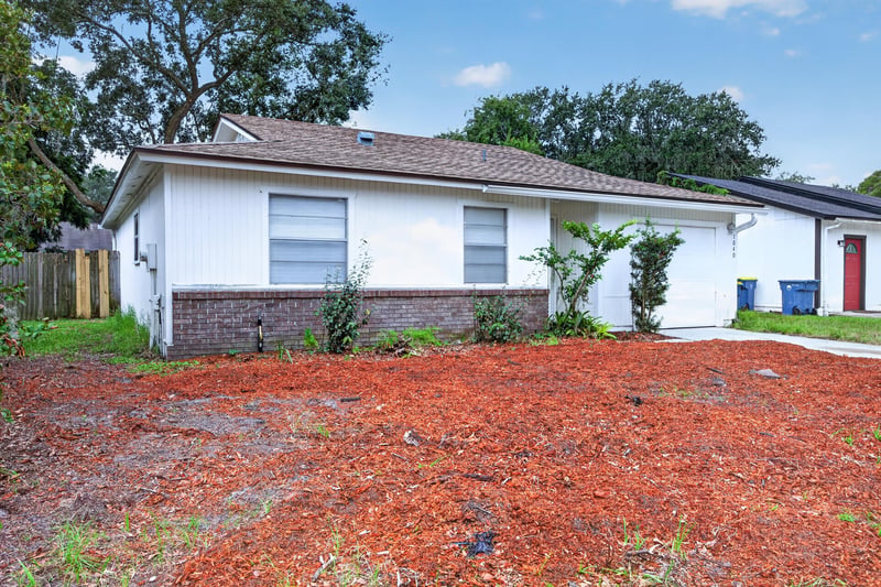 Front entrance with red door and landscaping at 1040 Willow Cove Ct E, Jacksonville, FL 32233