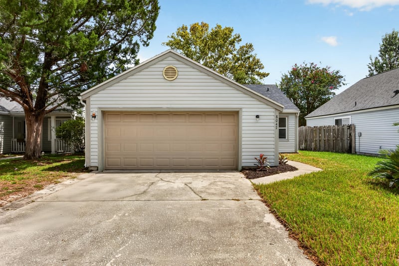 Front exterior view of gray ranch home with landscaped lawn at 8047 Mactavish Way E, Jacksonville, FL 32244