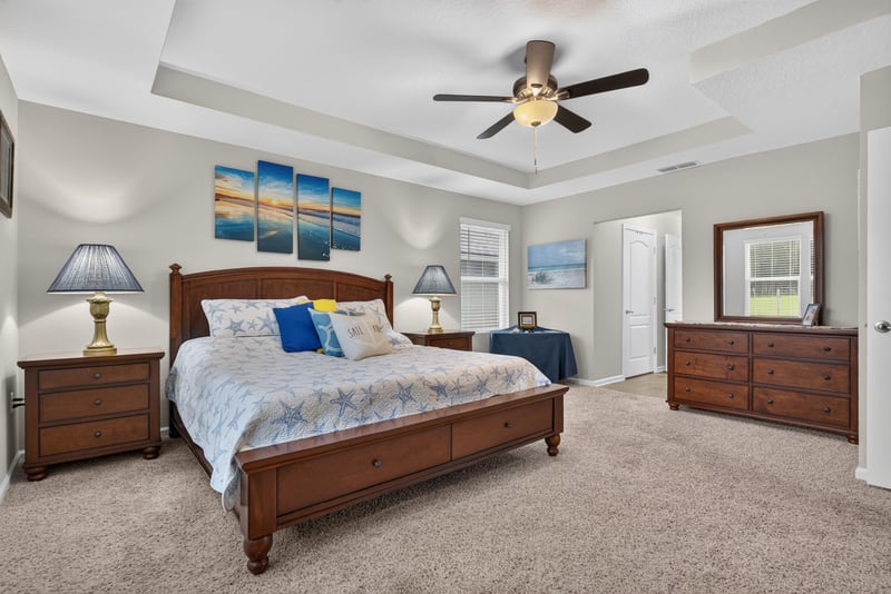 Primary bedroom with dresser and lamp at 4319 Green River Pl, Middleburg, FL 32068