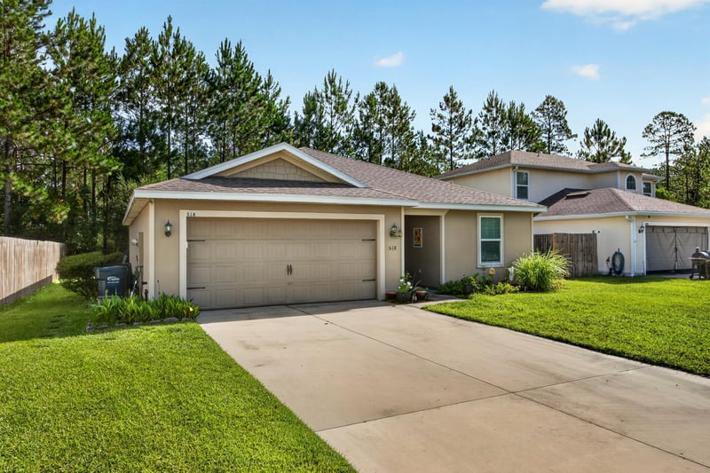 Street-side front view showing driveway and garage at 518 Matecumbe Ct, Macclenny, FL