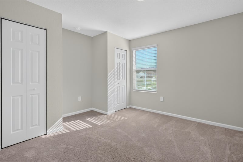 Second bedroom with closet doors and window at 4024 Bay Hawk Ct, Jacksonville, FL