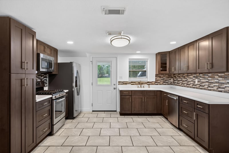 Kitchen with white exterior door and dark cabinetry at 1619 Hammond Blvd, Jacksonville, FL