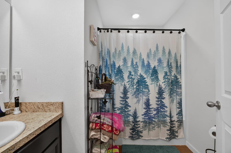 Second bathroom with pine-tree shower curtain at 518 Matecumbe Ct, Macclenny, FL