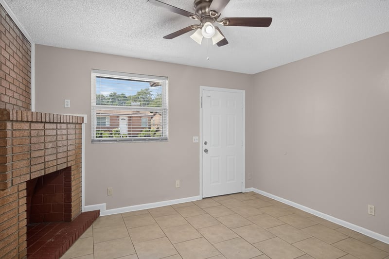 Living room corner with brick fireplace and window at 8067 Parental Cir, Jacksonville, FL 32216
