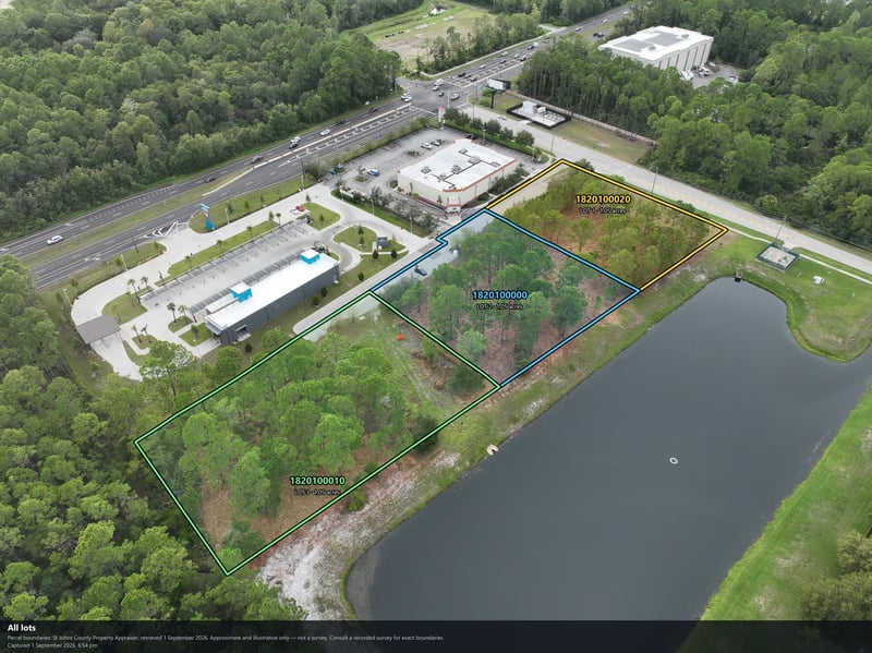 Aerial view of the wooded lot and pond with an adjacent commercial building at 4900 US-1, St. Augustine, FL 32086