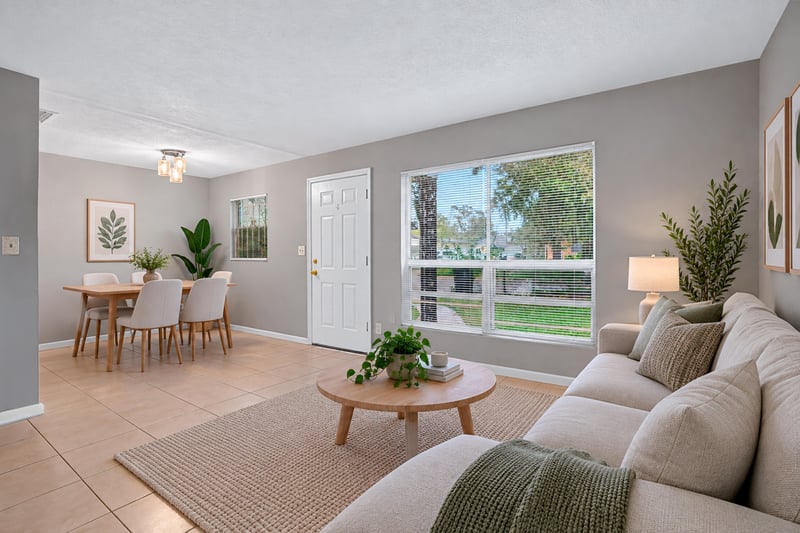 Virtually staged living and dining area with sofa and table at 4030 Leonard Cir W, Jacksonville, FL 32209