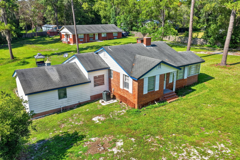 Front exterior view showing carport and mature trees at 5745 110th St, Jacksonville, FL 32244