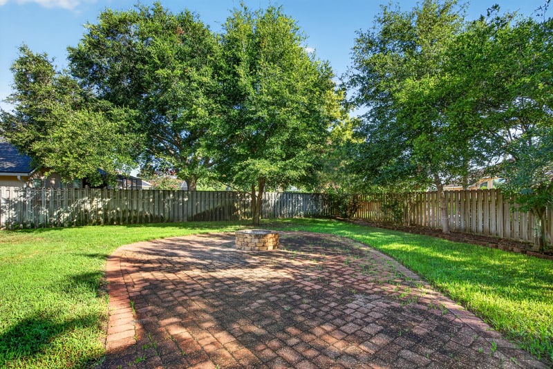 Backyard with paver path and fire pit area at 470 Sparrow Branch Cir, Jacksonville, FL 32259