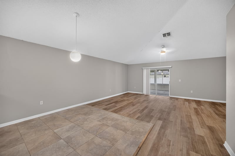Living space with wood-look floor and door to backyard at 1845 Saga Ct, Middleburg, FL