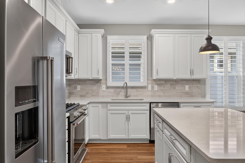 Kitchen with range, white cabinets and plantation shutters at 171 Oyster Shell Ter, Nocatee, FL 32081