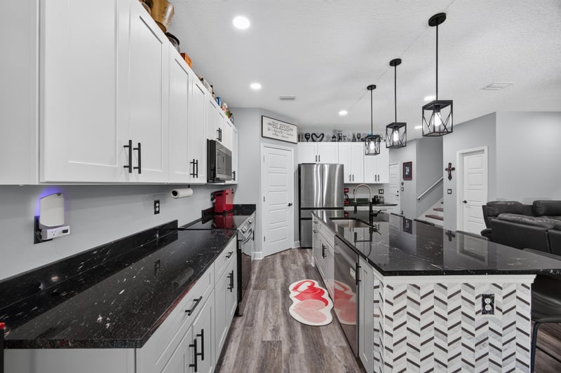 Kitchen counter view with black countertop and white cabinetry at 2817 Camel Cir, Middleburg, FL