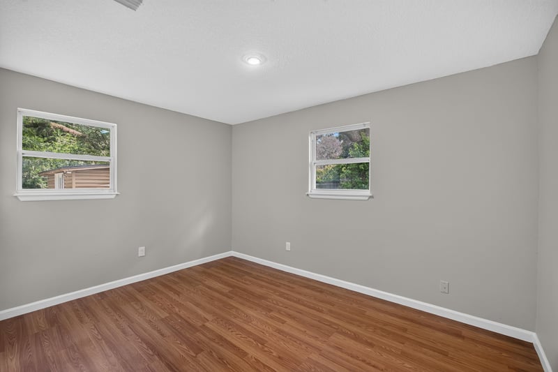 Empty bedroom with wood floor and window at 7015 Miss Muffet Ln N, Jacksonville, FL 32210