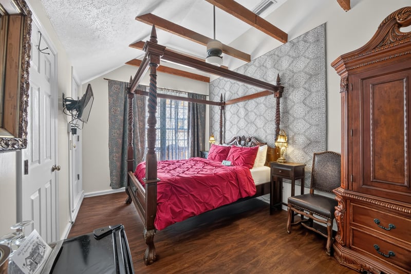 Bedroom with a four-poster bed and wood armoire at 115 Cordova St, St. Augustine, FL