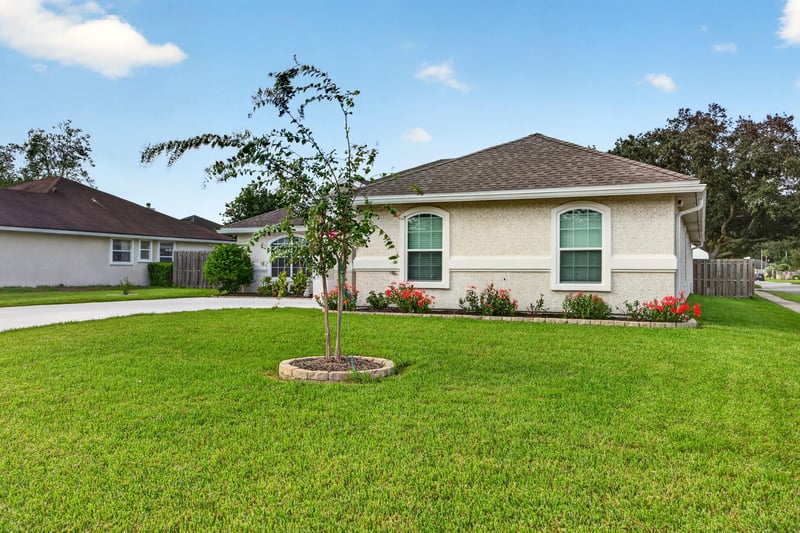 Front exterior with blue shutters and landscaped yard at 12825 Kelsey Island Dr, Jacksonville, FL 32224