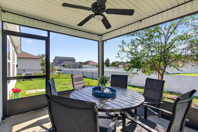 Screened lanai with dining set and ceiling fan at 589 Seville Pkwy, St. Augustine, FL