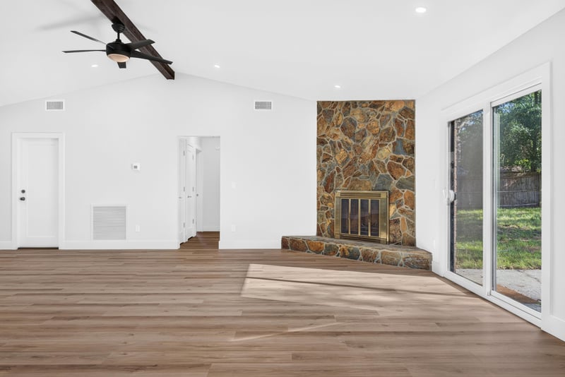 Living area with stone fireplace and sliding glass doors at 8453 Boysenberry Ln W, Jacksonville, FL