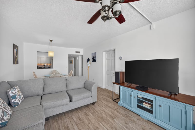 Living room with sofa, TV and blue media cabinet at 601 1st St S, Jacksonville Beach